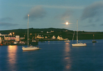 Moon setting at Portmagee Harbour, Kerry, Ireland.